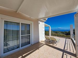 a balcony with chairs and a view of the ocean at Vasilopoulos Estate in Koroni