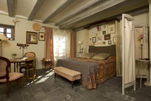 a bedroom with a bed and a table and a chair at Alodia in Alquézar