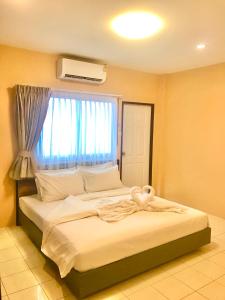 a bedroom with a large bed with a window at The Luka Guesthouse and Restaurant in Patong Beach