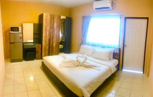 a bedroom with a large white bed with a window at The Luka Guesthouse and Restaurant in Patong Beach