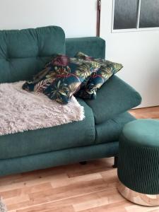 a green couch with a pillow on top of it at Kapitula centrum in Banská Bystrica