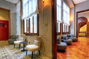 a room with chairs and tables and windows at Boutique Hotel Cordial Plaza Mayor de Santa Ana in Las Palmas de Gran Canaria