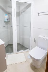 a white bathroom with a shower and a toilet at Estancia Dacil in La Orotava