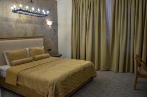 a bedroom with a bed and a chandelier at Shirvanshah Hotel in Baku