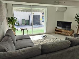 un soggiorno con divano e TV di ZIN AND GREEN JACUZZI SuperbeT2 spacieux idéalement situé a Vitrolles