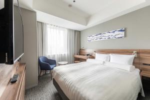 a hotel room with a bed and a television at Far East Village Hotel Tokyo Ariake in Tokyo