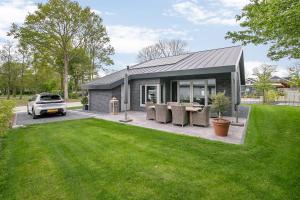 a small house with a car parked in a yard at VILLA ARYVE in See-, Strand- und Golfplatznähe inklusive NETFLIX, Bad en Suite und Wohlfühlgarantie in Dirkshorn