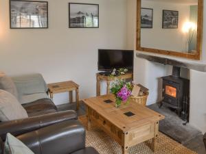a living room with a couch and a wood stove at Sunnyside in Delabole