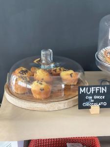 a glass display with blueberry muffins on a table at Alba B&B in Cattolica
