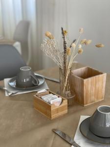una mesa con una caja de madera y un jarrón con flores en Alba B&B en Cattolica