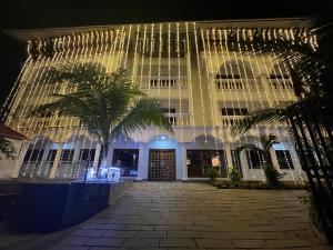 a building with a palm tree in front of it at Sajjoys in Varkala