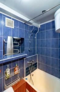 a blue tiled bathroom with a tub and a shower at Kvartirkoff na Geroev Dnepra 3 in Kyiv