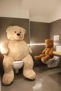 two large teddy bears sitting on a toilet at Hotel Galli's - Centro in Livigno