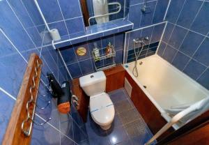 a blue tiled bathroom with a toilet and a bath tub at Kvartirkoff na Geroev Dnepra 3 in Kyiv