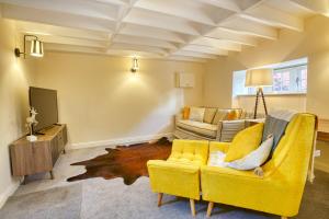 een woonkamer met een gele bank en een tv bij Pass the Keys Homey flat in Sleaford Centre in Sleaford