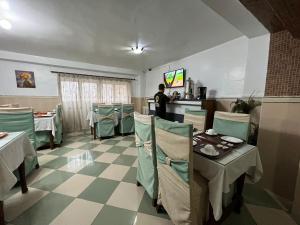 restauracja ze stołami i krzesłami oraz mężczyzna w kuchni w obiekcie Le cheval blanc w mieście Oran