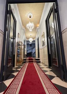 un corridoio con tappeto rosso e lampadario pendente di Le cheval blanc a Orano