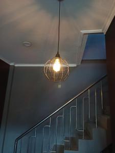 a light hanging from a ceiling with a staircase at Ganjar Homestay in Sentool