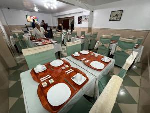 un comedor con mesas y sillas y una persona en un restaurante en Le cheval blanc, en Orán