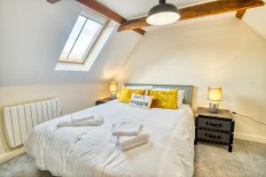 een slaapkamer met een groot wit bed met gele kussens bij Pass the Keys Homey flat in Sleaford Centre in Sleaford