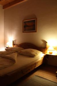a bedroom with a bed with two lamps on it at Weingut -1869- Brunnenhof in Hatzenport