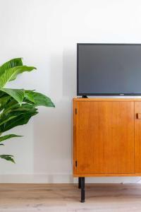 a flat screen tv sitting on top of a wooden cabinet at Vieux Port : Le Pavillon in Marseille