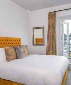 a bedroom with a large white bed and a window at Keswick Lake Road Apartments in Keswick