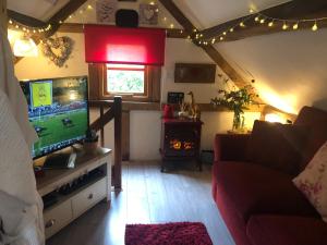 sala de estar con TV y sofá en Soldiers Cottage, with HOT TUB, dog friendly, great views en Hereford