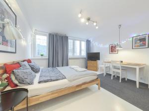 um quarto com uma cama, uma secretária e uma mesa em Sliska apartment Warsaw em Varsóvia