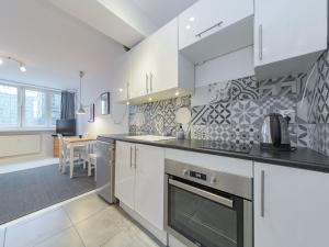a kitchen with white cabinets and a stove top oven at Sliska apartment Warsaw in Warsaw