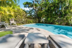 a swimming pool with two chairs and a table at Sundown Lodge 1 Edgar Bennett Avenue 14 in Noosa Heads