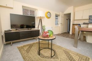 a living room with a television and a table with a bowl of fruit at Pass the Keys Cosy flat in the Town Centre in Sleaford