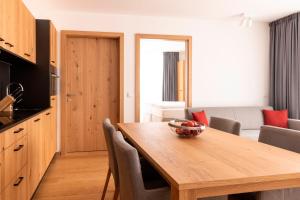 una cucina e una sala da pranzo con tavolo in legno di All-Suite Resort Paznaun a Galtür