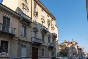 un alto edificio con balconi su una strada della città di CasaCasalis - Immersi nella Torino Liberty a Torino