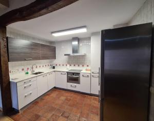 a kitchen with white cabinets and a black refrigerator at HARO EXPERIENCE Baco in Haro +26 photos
