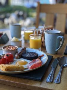 um prato de comida de pequeno-almoço numa mesa de madeira em Clarence House em Keswick