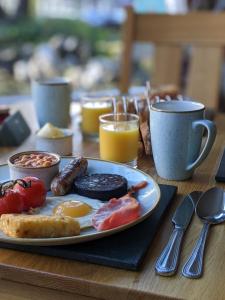 a plate of breakfast food on a wooden table at Clarence House in Keswick