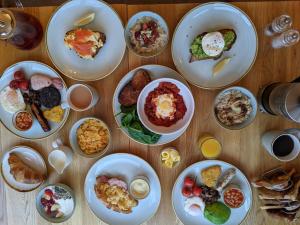 a table with plates of breakfast food on it at Clarence House in Keswick