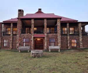 a large brick building with two benches in front of it at Stone Castle, Dullstroom Country Estate in Dullstroom