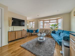 a living room with a blue couch and a tv at Pass the Keys Stylish 2BR Apartment Parking x 2 Oxford in Oxford