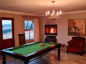 a living room with a pool table and a chandelier at Stone Castle, Dullstroom Country Estate in Dullstroom
