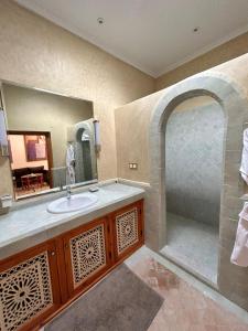 uma casa de banho com um lavatório e um espelho grande em Palais Claudio Bravo em Taroudant