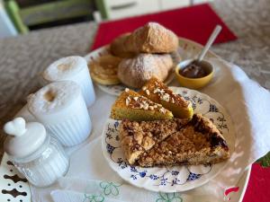 um prato de comida com pão e bolos sobre uma mesa em “Casa Amélie” em Grottaferrata