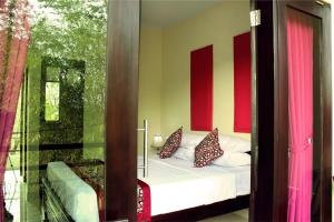 a bedroom with a bed with red and yellow walls at Ramantika Bali House in Jimbaran