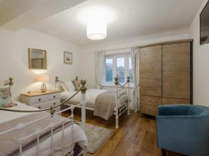 a bedroom with two beds and a chair and a window at Harbour View - Ukc2303 in Wainfleet All Saints