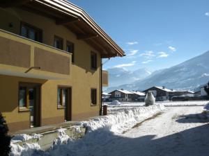 a snow covered street next to a building at Appartement Dominik in Uderns