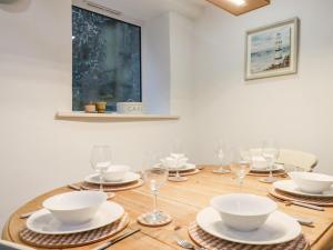 a dining room table with plates and wine glasses at Beach Road House in Ilfracombe