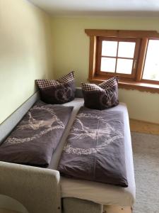 Bett in einem Zimmer mit zwei Kissen darauf in der Unterkunft Hocheckhuette On Top of the Kitzbuehel Hahnenkamm Mountain in Kitzbühel