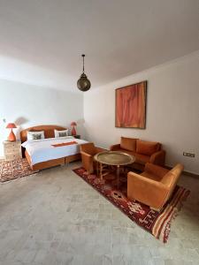 a bedroom with a bed and a couch and a table at Palais Claudio Bravo in Taroudant