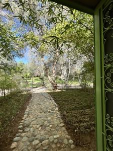 un camino de piedra que conduce a un parque con un árbol en Palais Claudio Bravo en Taroudant